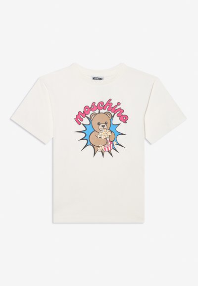 Λευκό T-shirt με καρτουνίστικη αρκούδα που κρατάει ποπ κορν, μπλε υπόβαθρο με λάμψεις και ροζ κείμενο "Moschino" πάνω από την αρκούδα.