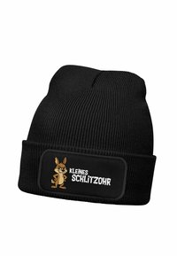 Black knitted beanie with ribbed texture, featuring a rectangular patch with an illustrated cartoon rabbit and the text "KLEINES SCHLITZOHR."