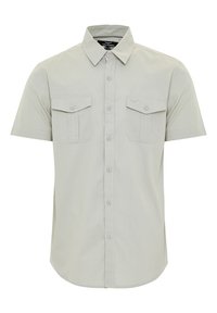 Camisa de manga corta de color gris claro con cuello tipo botón, dos bolsillos en el pecho, cierre frontal con botones y una textura suave y tejida.