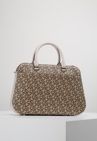 Sac à main structuré marron et beige avec un motif monogramme répété, bords arrondis et deux poignées pâles, présenté sur un piédestal blanc.