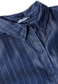 Camicia di denim con base blu scuro e righe verticali azzurre chiare. Dotata di colletto e chiusura con bottoni. Tessuto morbido.