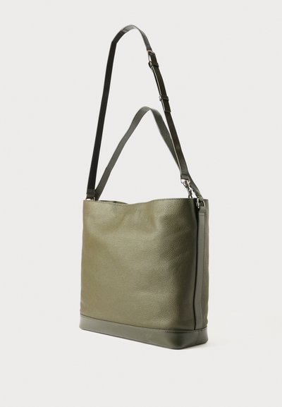 Bolsa tote de couro verde oliva com uma superfície texturizada, alça ajustável e acessórios em prata. Projetada com uma forma suave e mole.