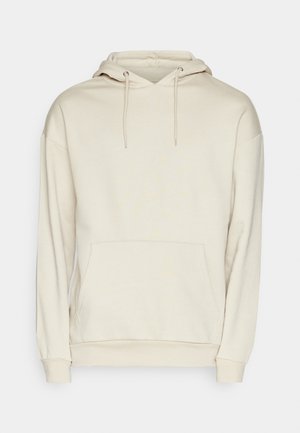 Felpa con cappuccio beige realizzata in tessuto morbido, dotata di una tasca a marsupio e polsini a coste. Il design ha una vestibilità rilassata e dettagli minimi.