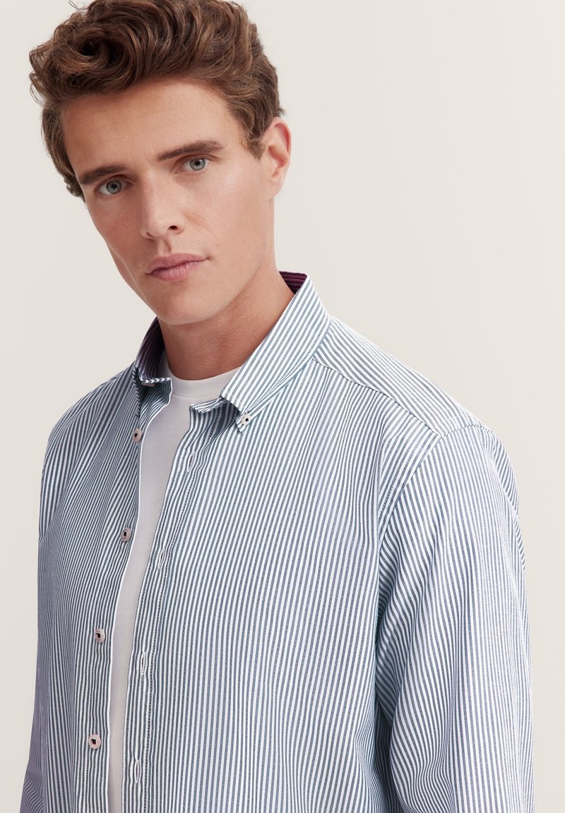 Chemise à rayures bleu clair et blanche avec un col bordeaux contrastant, dotée d'une coupe classique et d'une texture en coton doux.