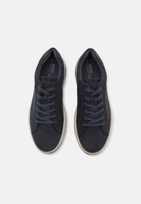 Navy blue sneakers with a smooth suede finish, round toe, and six lace holes. Cream-colored sole with subtle texture and perforated accents.