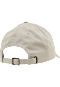 Beige katoenen honkbalpet met een gebogen rand, verstelbare band aan de achterkant en ventilatieopeningen. Gladde textuur en eenvoudig ontwerp.