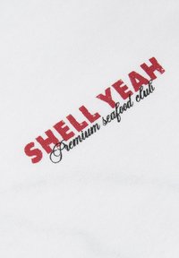 Κόκκινο κείμενο με την ένδειξη "SHELL YEAH" πάνω από μαύρο καλλιγραφικό κείμενο που λέει "Premium seafood club" σε λευκό υφασμάτινο φόντο.