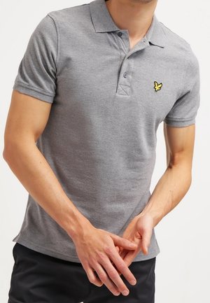 Polo grigio in cotone, dotato di una chiusura a tre bottoni, maniche corte e un piccolo logo a forma di farfalla gialla sul petto.