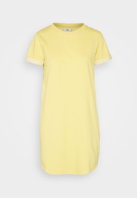 Robe t-shirt en coton jaune avec des manches courtes roulées et un col rond. Coupe simple et droite avec une texture douce.