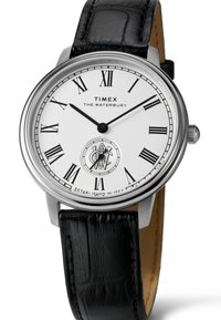 Timex Waterbury watch with a white dial, black Roman numerals, stainless steel case, and black leather strap featuring a crocodile texture.