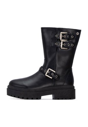 Botas de cuero negras hasta el tobillo con dos acentos de hebilla plateada, suela de plataforma gruesa y un acabado suave; cuenta con una textura de goma negra en la suela.