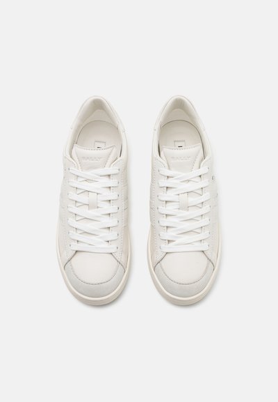 Hvide lædersneakers med lav silhuet, teksturerede detaljer, rund tå og flade snørebånd. Sålen er let off-white med diskret søm.