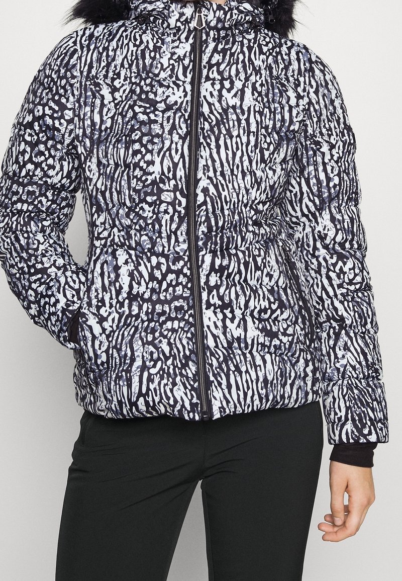 Doudoune à motif abstrait noir et blanc, dotée d'une fermeture éclair frontale, de poches latérales et d'une capuche bordée de fausse fourrure. Tissu texturé.