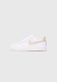 Valkeat Nike Air Force 1 -kengät, joissa on sileä päällinen, vaaleanbeigejä yksityiskohtia ja rei'itettyjä elementtejä. Varustettu tekstuuripohjalla ja nauhoitusjärjestelmällä.