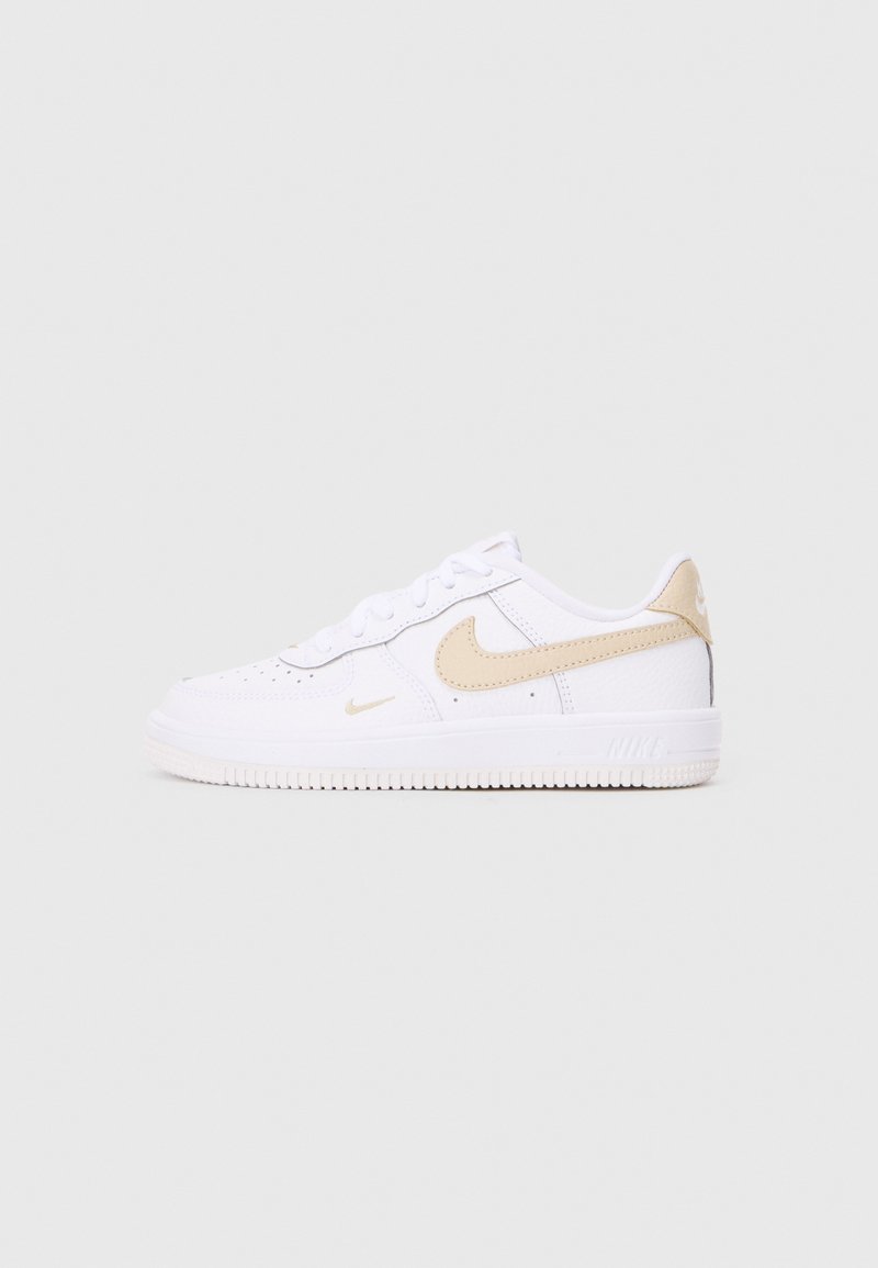 Valkeat Nike Air Force 1 -kengät, joissa on sileä päällinen, vaaleanbeigejä yksityiskohtia ja rei'itettyjä elementtejä. Varustettu tekstuuripohjalla ja nauhoitusjärjestelmällä.