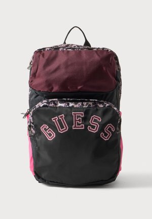 Zaino con tasca superiore bordeaux, tasca frontale nera con scritta "GUESS" e pannelli laterali rosa su sfondo semplice.
