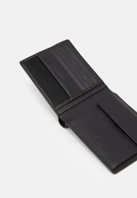 Zwarte leren portemonnee met een gladde textuur, voorzien van meerdere kaartsleuven en een ritsvak. Eenvoudig ontwerp en minimalistische branding.