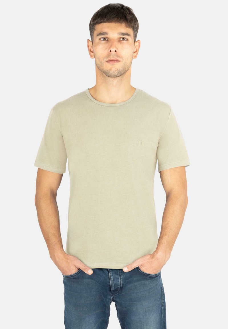 Hellgrünes Baumwoll-T-Shirt mit Rundhalsausschnitt und kurzen Ärmeln. Verfügt über ein kleines gesticktes Logo auf der linken Seite. Getragen mit Jeans.