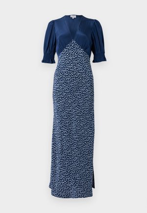 Robe bleu marine avec un décolleté en V, des manches bouffantes et un motif à pois blancs. Présente un corsage ajusté et une longue jupe avec une fente sur le côté.