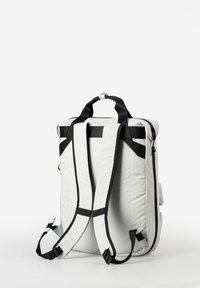 Zaino bianco con schienale imbottito, spallacci neri regolabili, maniglia superiore e tasca laterale. Presenta un design elegante e minimalista.