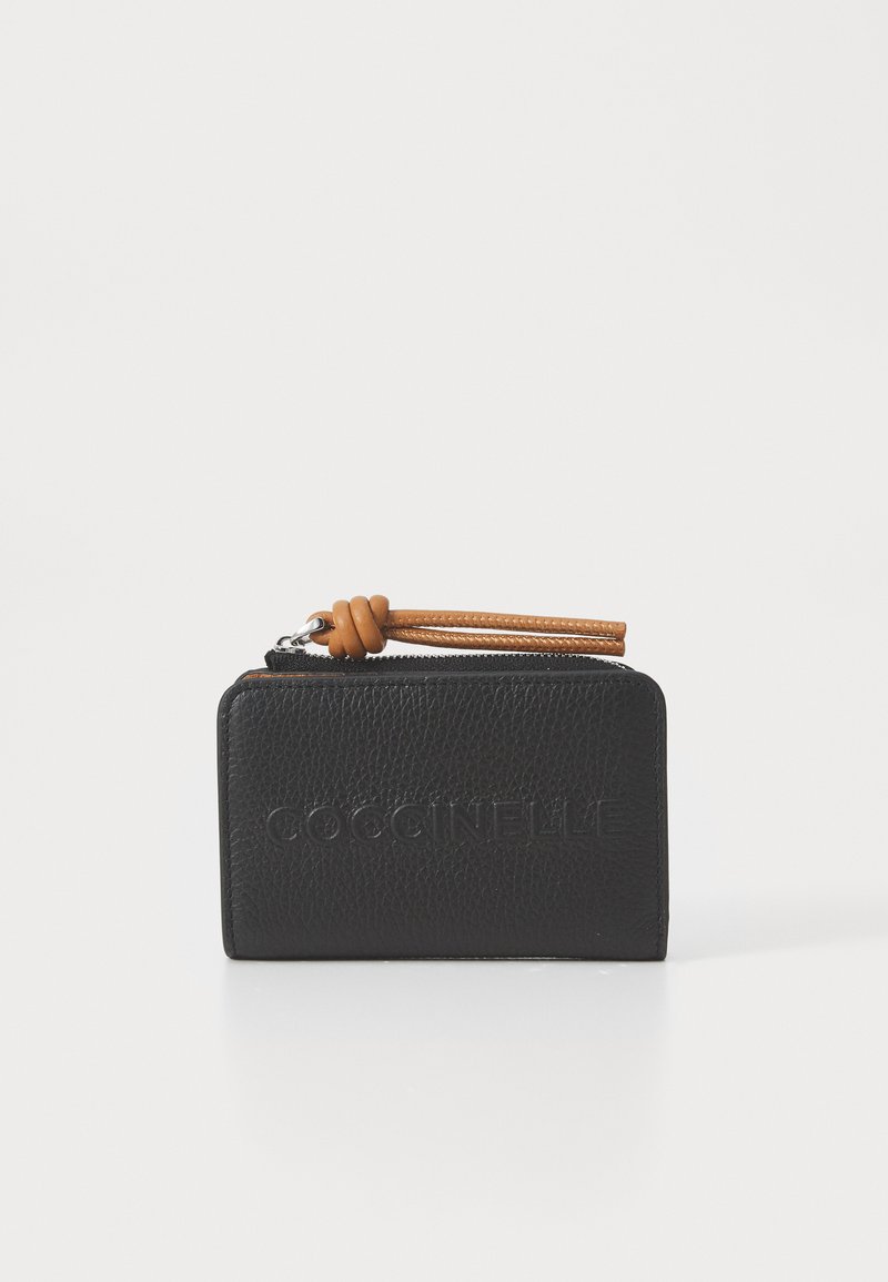 Μαύρο δερμάτινο συμπαγές πορτοφόλι με υφή, κλείσιμο με φερμουάρ και καφέ δερμάτινο κρεμασάκι με λεπτομέρεια κόμπου. Λογότυπο χαραγμένο μπροστά.