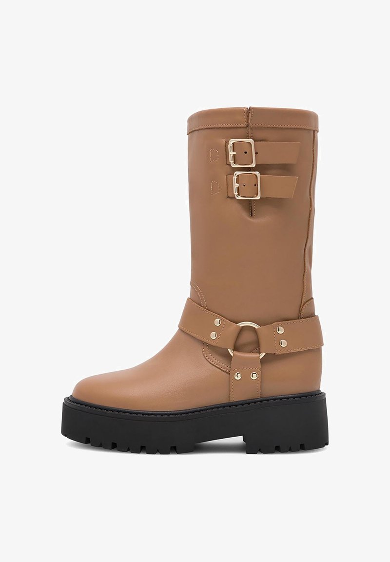 Fekete műbőr térdigolylevágó csizma, két állítható csattal, egy kör alakú csatt díszítéssel és egy tömzsi fekete platform talppal.