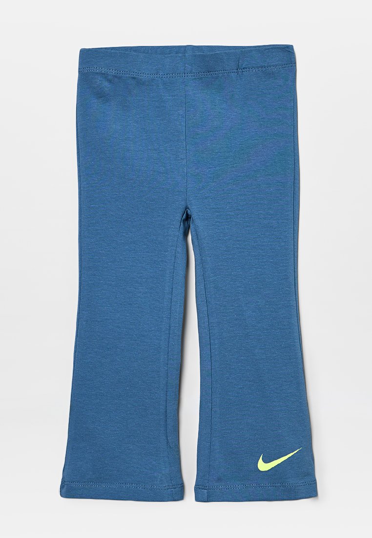Pantalons de sport bleus en tissu doux et extensible. Présente une taille lisse et un petit logo Nike vert près de l'ourlet.