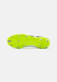 Suola di scarpa da calcio con tacchetti di un vivace verde lime, caratterizzata da un motivo testurizzato e accenti grigi, con tacchetti sporgenti e frastagliati per una migliore aderenza.