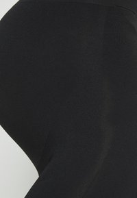 Svarta leggings tillverkade av stretchmaterial, med en slät yta och en figurnära design. Inga märkbara mönster eller detaljer synliga.