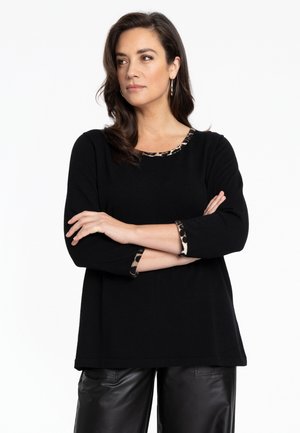 Schwarzer Pullover mit Dreiviertelärmeln, verziert mit Leopardenmuster-Akzenten am Ausschnitt und an den Ärmelabschlüssen. Weiche Textur, lockere Passform.