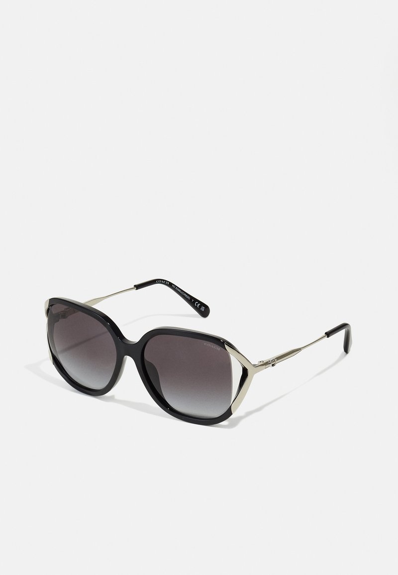 Ochelari de soare cu un gradient negru și gri, cu un cadru mare și unghiular, accente metalice și brațe subțiri, având un branding subtil pe tăietură.