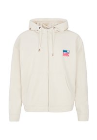 Felpa crema con zip, cappuccio regolabile e tasche frontali. Presenta un colorato patch con logo con elementi blu, rosa e bianchi.