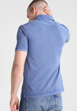 Korte mouwen polo shirt in een lichtblauwe stof, met een kraag en een relaxed fit. Donkerder stiksels accentueren de zoom en de mouwen.