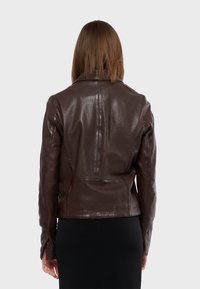 Veste en cuir marron au design ajusté, texture lisse et détails de coutures. Dispose de manches longues et d'un col classique.