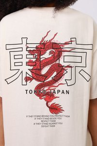 Κόκκινος δράκος που είναι πλεγμένος με μεγάλα ιαπωνικά γράμματα και το κείμενο «Τόκιο Ιαπωνία» σε λευκό πουκάμισο, με ένα εμπνευστικό απόφθεγμα από κάτω.