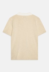 Polo shirt beige a maniche corte con colletto bianco. Il tessuto ha una consistenza liscia e presenta un delicato motivo melange.