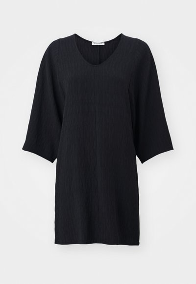 Sort tunika med V-udskæring og brede trekvartærmer. Det strukturerede stof har et diskret mønster, som giver en afslappet silhuet.