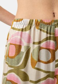 Shorts mit elastischem Bund aus leichtem Stoff mit buntem Blumenmuster in Pink-, Grün- und Brauntönen. Glatte Textur mit fließendem Design.