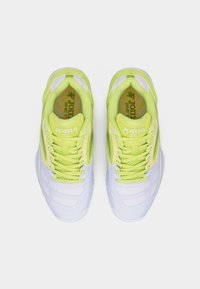 Ζευγάρι λευκών και νέον πράσινων παπουτσιών τρεξίματος Joma, σε θέα από πάνω, σε απλό λευκό φόντο.