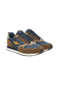 Scarpe sportive con rete blu navy e camoscio marrone, suole crema screziate e stemma ricamato. Design con lacci e collarino imbottito.