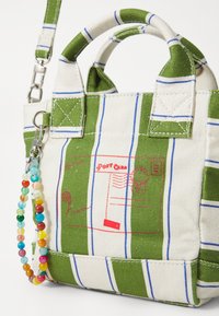 Grün-weiße gestreifte Canvas-Tasche mit zwei Griffen, roter Postgrafik und einem Perlenriemen. Verfügt über gestickte Akzente und eine strukturierte Form.