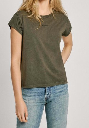Olive green short-sleeve t-shirt made of soft cotton. Features a crew neck and subtle logo detail on the chest. Paired with light blue jeans.