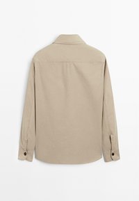 Beige langærmet skjorte med klassisk krave, knapmanchetter og en glat bomuldsstruktur. Ingen synlige mønstre eller detaljer.