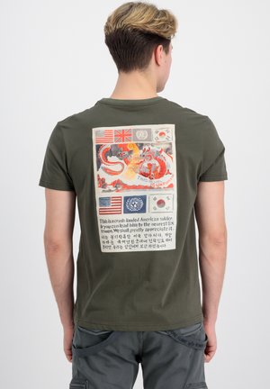Camiseta verde oliva con un diseño impreso en la parte posterior, que presenta banderas, una ilustración de un dragón y texto en inglés y coreano.