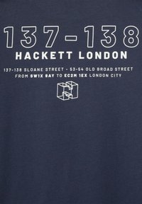 Mornarska pamučna majica sa istaknutim bijelim tekstom "Hackett London" i detaljima o lokaciji, uz jednostavan geometrijski logo.