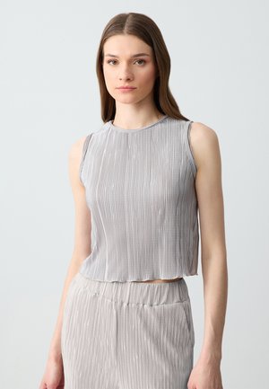 Top senza maniche grigio chiaro con un design a costine testurizzato, lunghezza cropped, scollatura a girocollo e tessuto morbido, abbinato a pantaloni coordonati a costine.