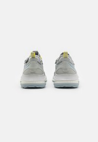 Sport shoes with a gray suede and mesh upper, white midsole, light blue outsole, yellow striped heel tab, and visible stitching details.