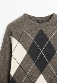 Pull en laine marron avec un grand motif losange argyle noir, blanc et gris, et un col rond côtelé.