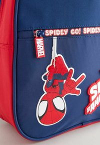 Mochila de tela roja y azul con un gráfico de Spiderman. Incluye un tirador de cremallera "Marvel" y una cinta con el texto "¡Spidey Go!".
