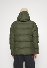 Olíva zöld puffert jacket kapucnival, steppelt dizájnnal és sima textúrával. A hátulról készült nézet egy lazább fazont és minimális részletezést mutat.